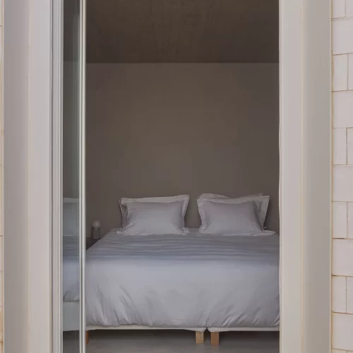 En-suite bedroom with private patio access at Casa na Terra underground villa Portugal