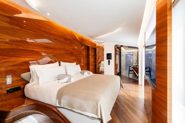 Minimalist luxury suite at Romeo Roma with curved walls and Carrara marble accents.