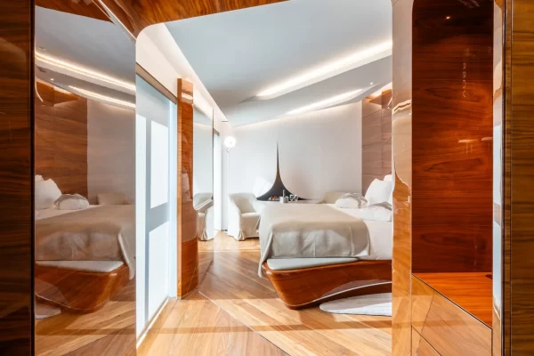 Minimalist luxury suite at Romeo Roma with curved walls and Carrara marble accents.
