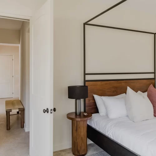 Minimalist bedroom at Sendero Hotel with floor-to-ceiling windows overlooking jungle canopy