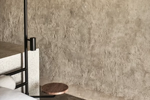 Minimalist interior of a wine tank suite with raw concrete walls and soft natural light